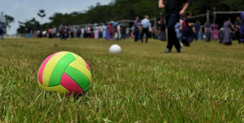 Immagine decorativa (una palla da basket su un prato in primo piano e dietro molta gente). Immagine decorativa (una palla da basket su un prato in primo piano e dietro molta gente)